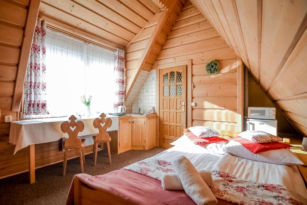 a bedroom with two beds and a table and a window at Domek na Harendzie in Zakopane