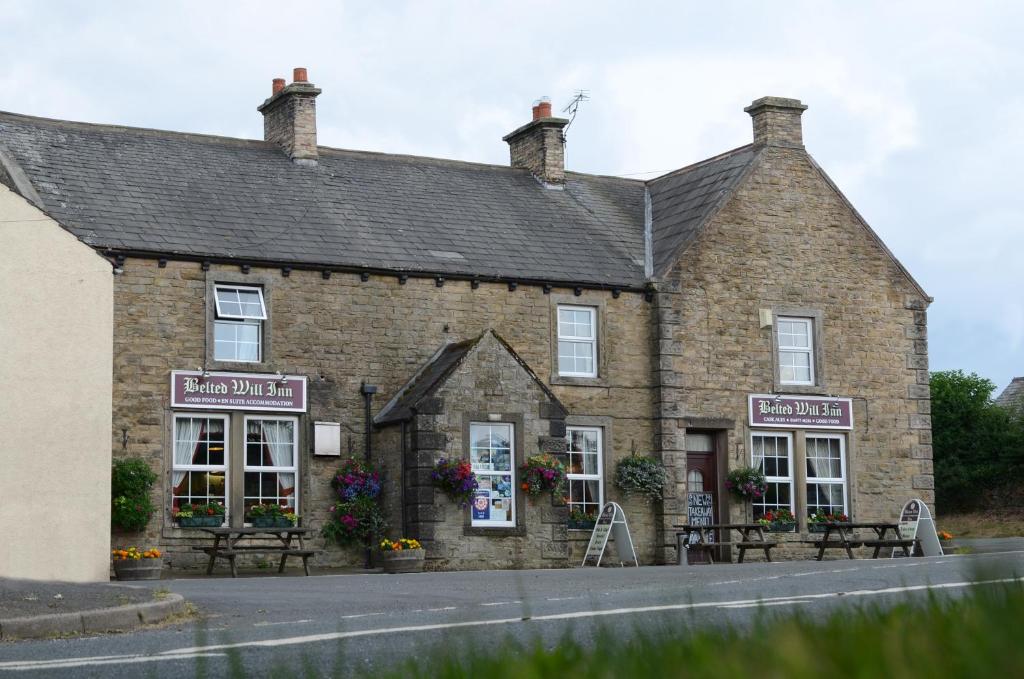 a brick building on the side of a road at The Belted Will Inn in Farlam