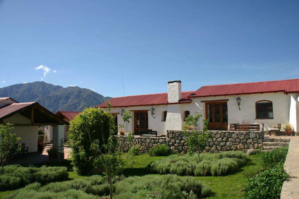 Estancia Las Carreras في ألمولار: منزل بسقف احمر وجدار حجري