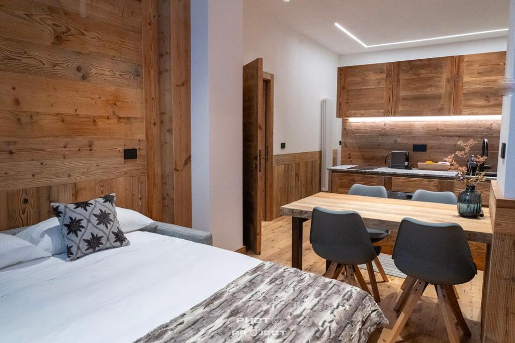 a bedroom with a bed and a table and chairs at Fior di Roccia Apartments- in centro Cervinia, sauna privata, Matterhorn dream in Breuil-Cervinia