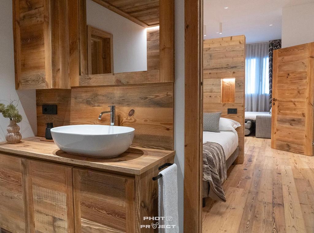 a bathroom with a sink and a bed in a room at Fior di Roccia Apartments- in centro Cervinia, sauna privata, Matterhorn dream in Breuil-Cervinia