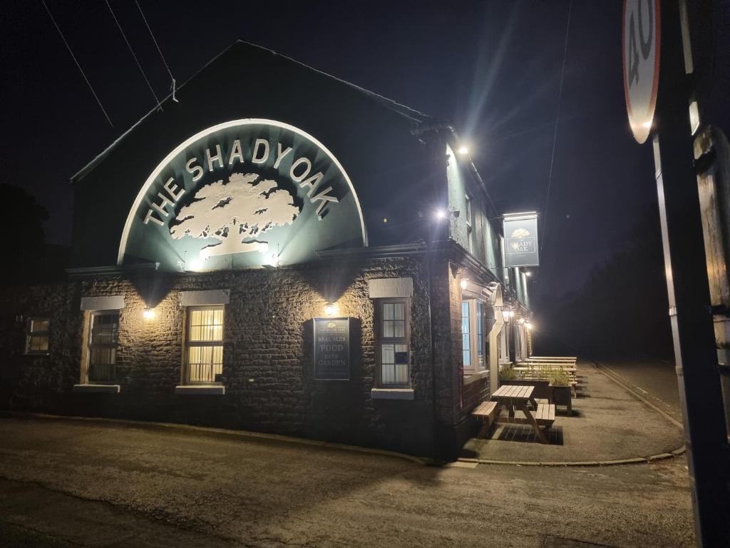 a building with a sign that reads the shakespeareodcast at night at The Shady Oak B&B in Highpeak Junction