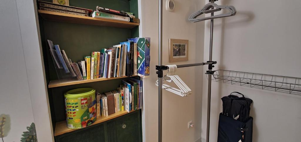 a book shelf filled with books next to a door at Les Nympheas, appart, grand jardin au calme, parking gratuit,15 min Disneyland, in Crécy-la-Chapelle