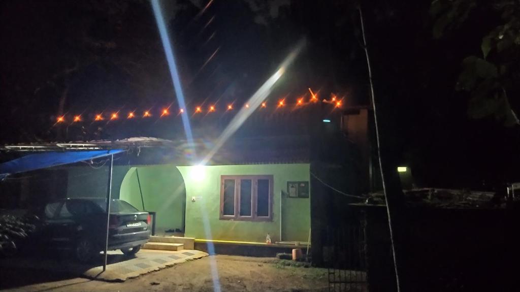 a house with a truck parked in front of it at night at Unnis Old Home in Adūr