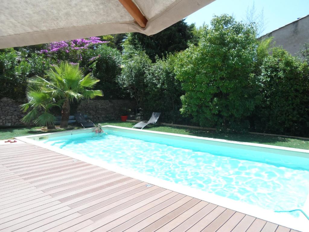 a swimming pool in a yard with an umbrella at Haut de villa Toulon Mourillon in Toulon