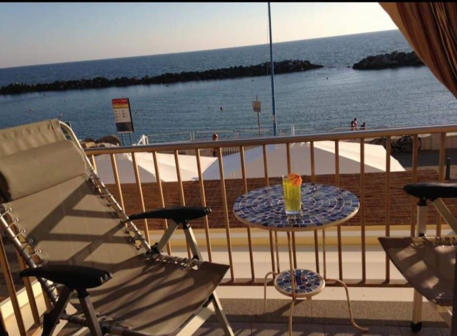 un balcón con una mesa con una bebida. en Casa Vacanze Marina di Pisa Catola en Marina di Pisa