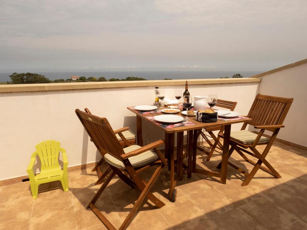 a dining table and chairs on a balcony with a view at LA LÍNEA DEL MAR in Trasierra