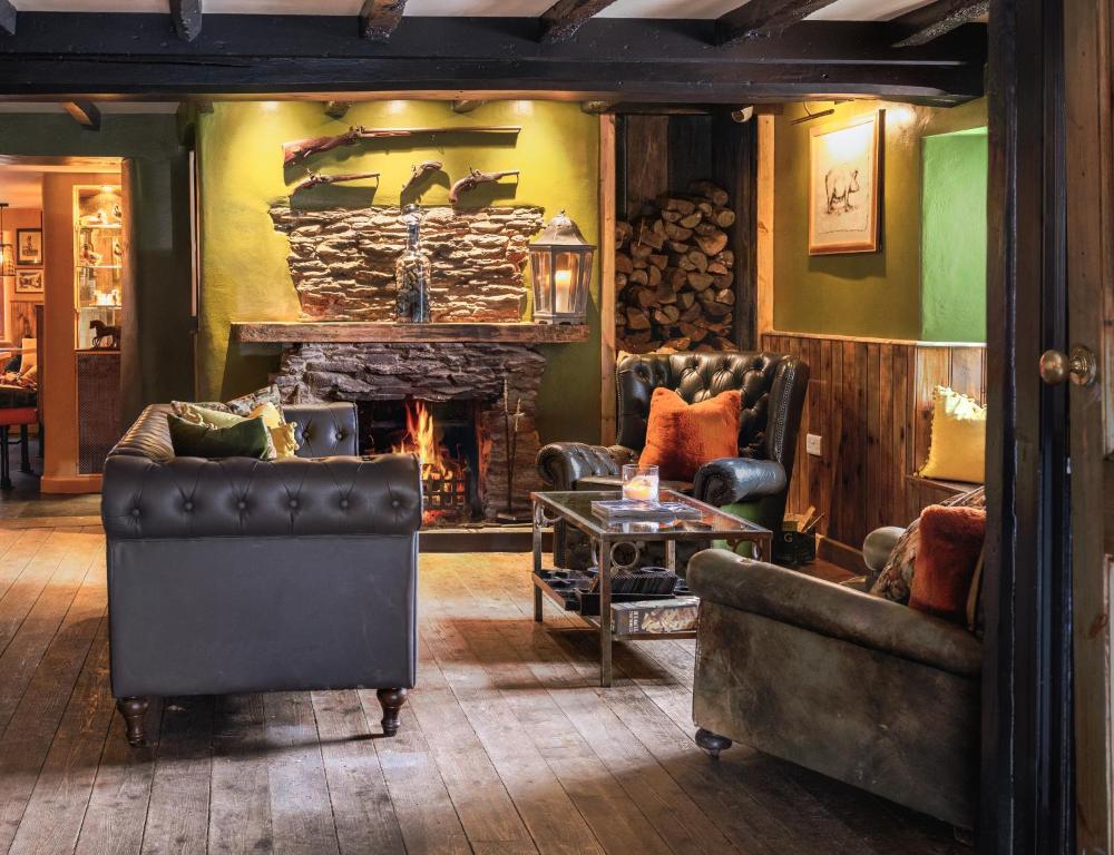 Upton的住宿－The Bittescombe Inn，客厅配有皮革家具和壁炉