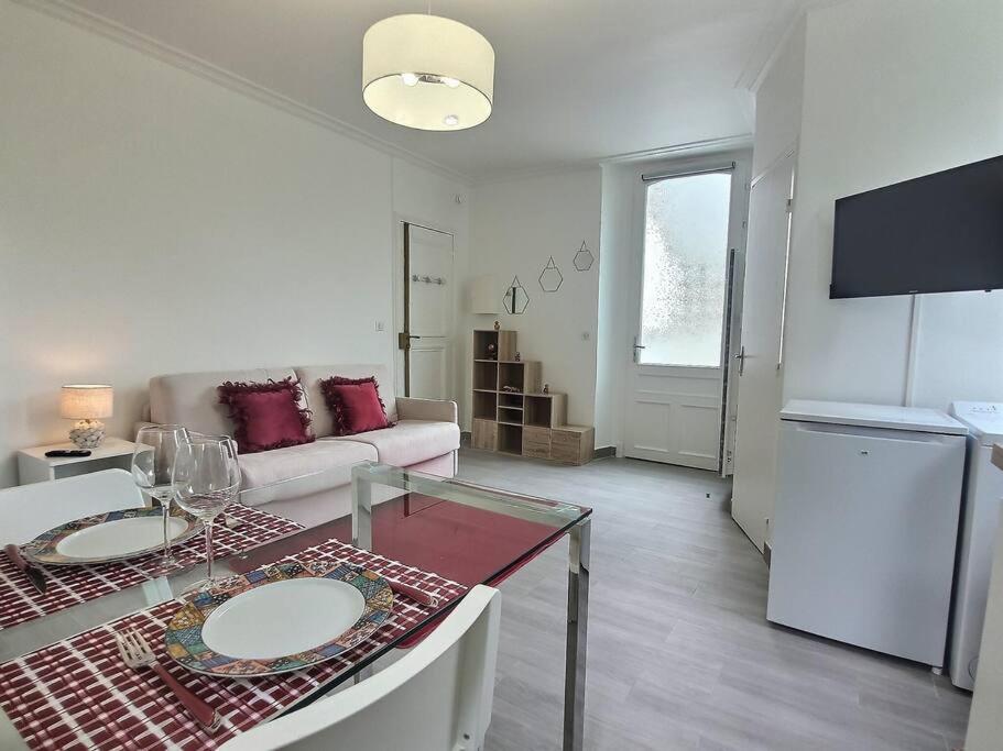 sala de estar blanca con mesa y sofá en Cosy des Rêves *Paris*Disney*, en Croissy-Beaubourg