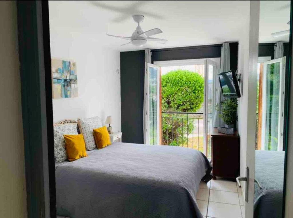 une chambre avec un lit avec des oreillers jaunes et une fenêtre dans l'établissement Le Marie Louise - Bord de mer lle Rousse Calvi Est, à LʼÎle-Rousse