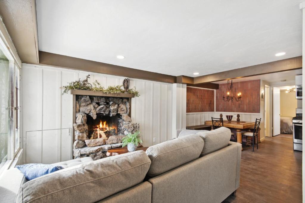 a living room with a couch and a fireplace at Kozy Cabin in Allenspark