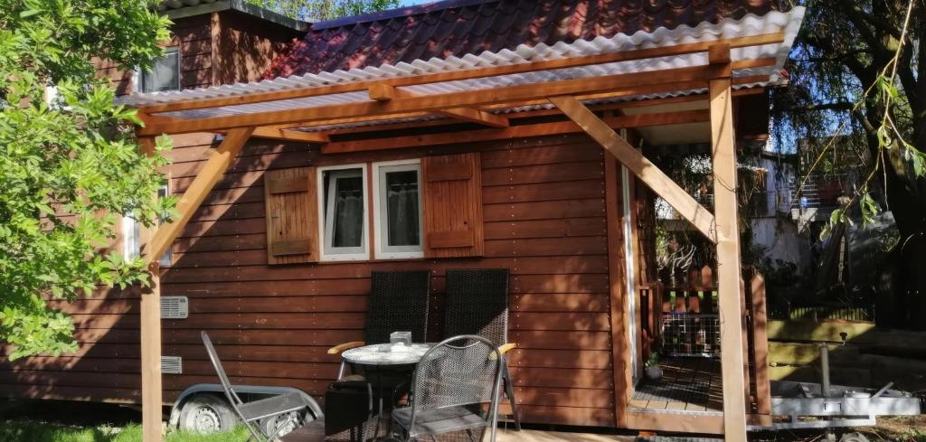 a house with awning and a table in front of it at Tiny House Schwarzwald in Rheinau