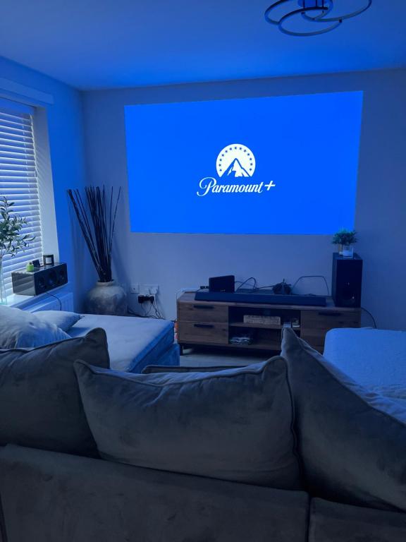 uma sala de estar com um sofá e um ecrã azul em Aycliffe Home Away From Home A1 em Newton Aycliffe