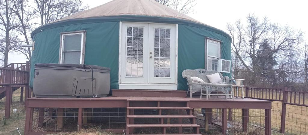 een groen prieel met twee stoelen op een terras bij Madison's ONLY yurt experience! in Vevay