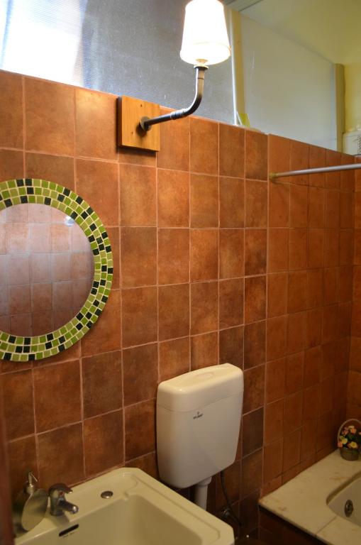 a bathroom with a toilet and a mirror and a sink at Habitaciones en Casa Céntrica cerca de todo in Colonia del Sacramento