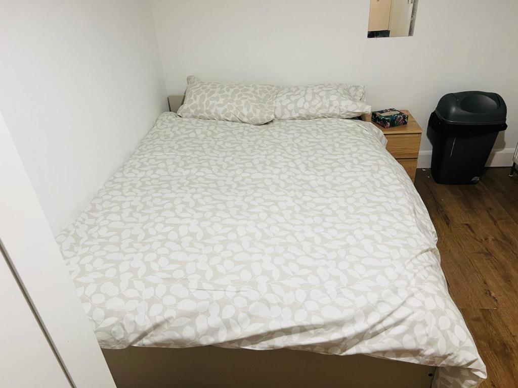 a bed in a bedroom with a white comforter at Double bed Room in London