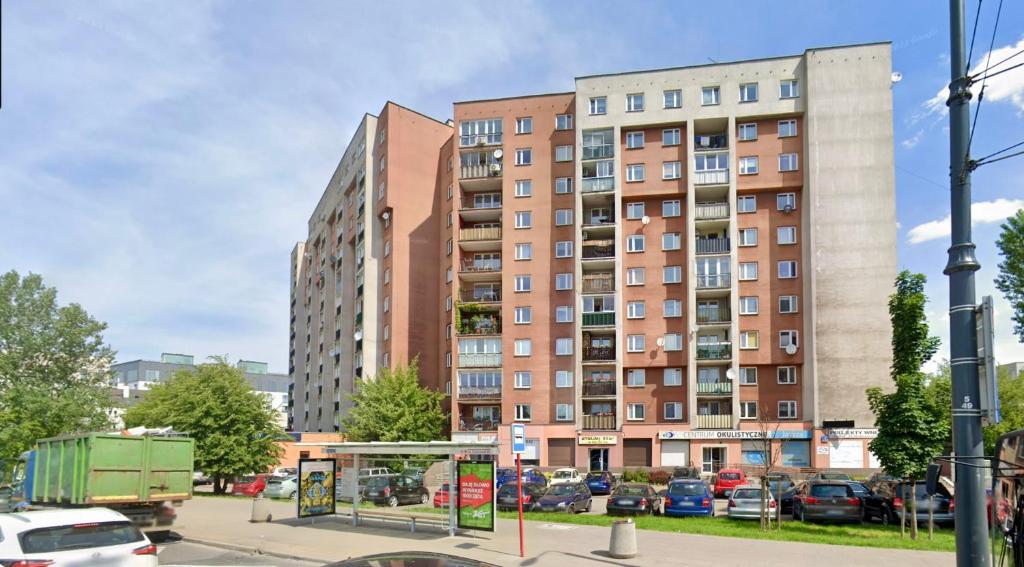 un edificio alto con auto parcheggiate in un parcheggio di Apartament Stadion - duży apartament blisko Stadionu Narodowego w Warszawie. a Varsavia