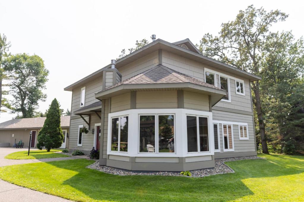 a house with a large window on a lawn at Bay Colony 761 - Lower in Nisswa