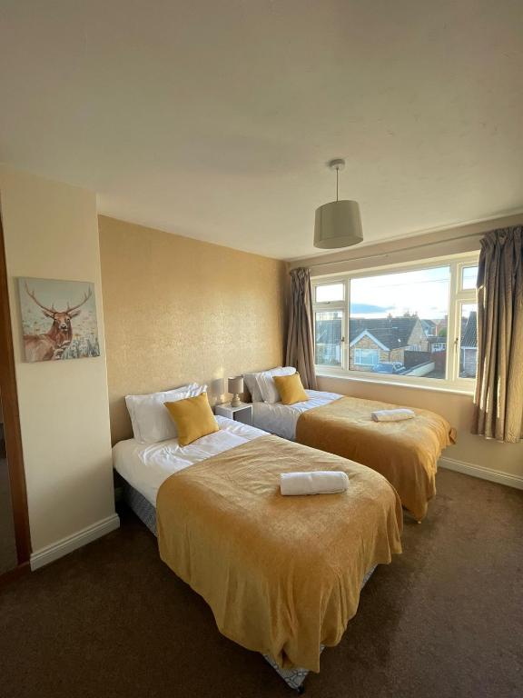 um quarto de hotel com duas camas e uma janela em Spacious 4-bed House in Leicester em Leicester