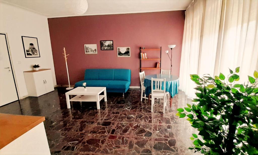 a living room with a blue couch and a table at Dimore Demetra in Canosa di Puglia