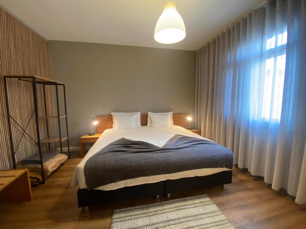 een slaapkamer met een bed en een groot raam bij Apartamentos São João in Horta