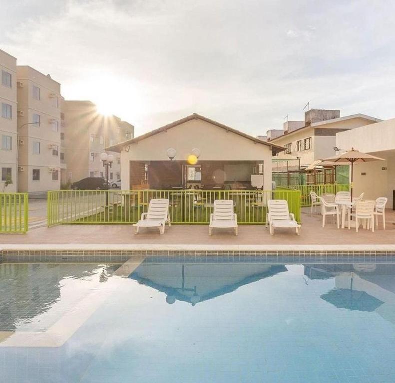 uma piscina com cadeiras e uma casa em Apartamento, 2 quartos com piscina em Paulista