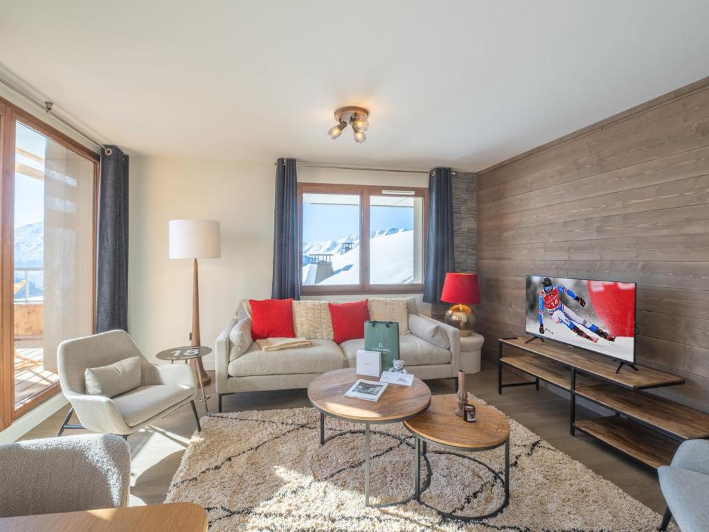 a living room with a couch and a tv at Bel appartement près des pistes, WiFi, animaux admis, parking - FR-1-645-46 in LʼHuez