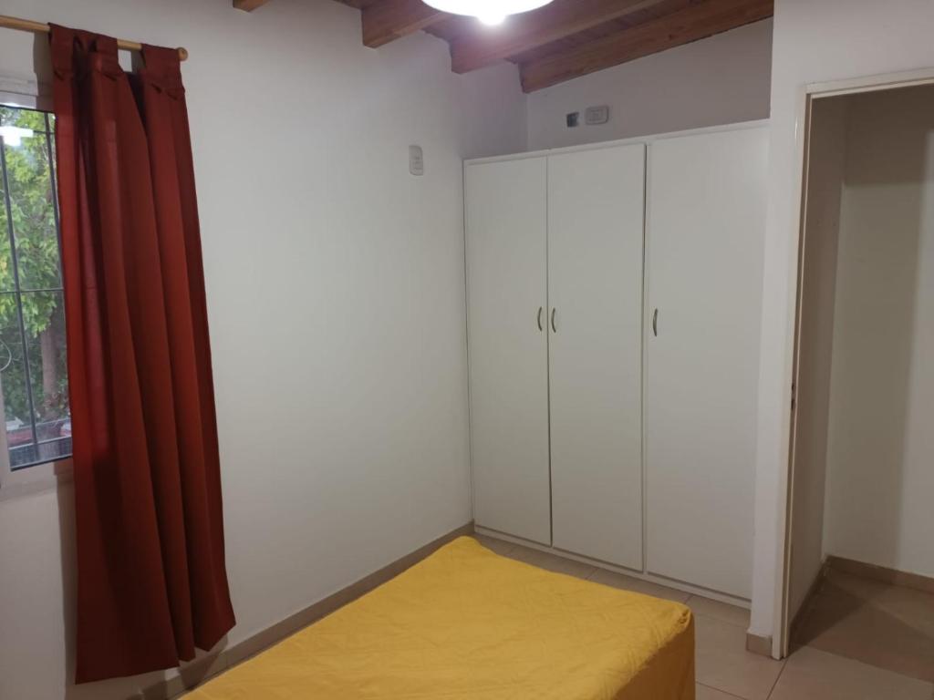 1 dormitorio con paredes blancas, 1 cama y ventana en Departamento céntrico en San Rafael