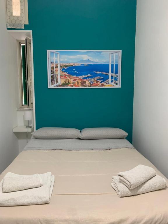 a bed in a room with a blue wall at DEA PARTHENOPE in Naples
