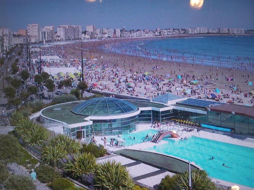 une plage avec une grande piscine et une foule de personnes dans l'établissement Appartement Vue Sur Mer, à Les Sables-dʼOlonne