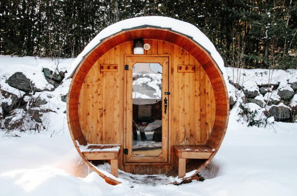 una casa hobbit de madera en la nieve en Suite 108 - Destination Mont-Orford en Magog-Orford