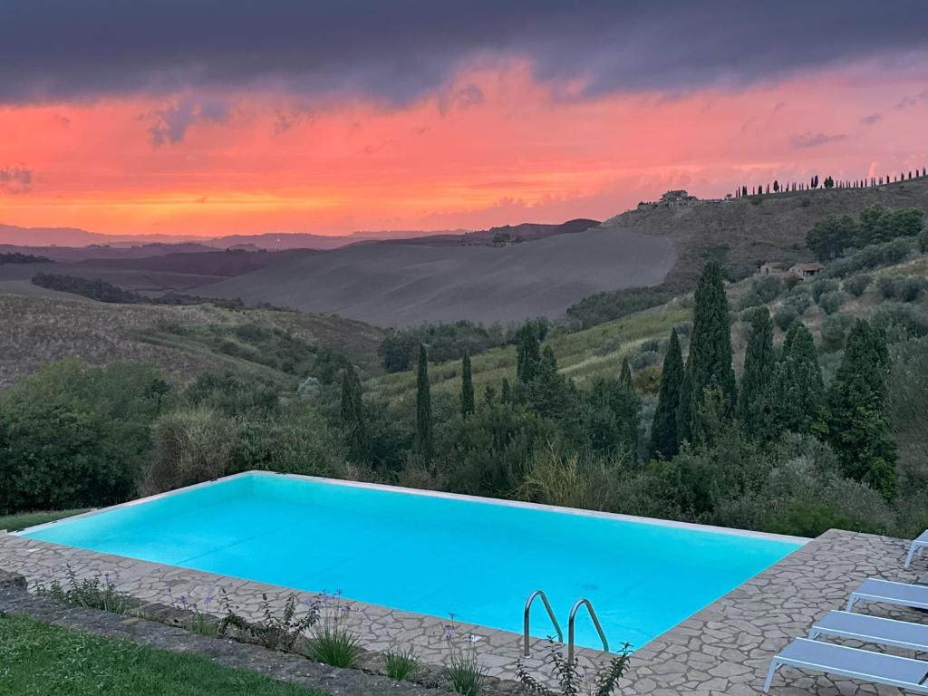 una piscina con puesta de sol en el fondo en Villa Cantucci, en Volterra
