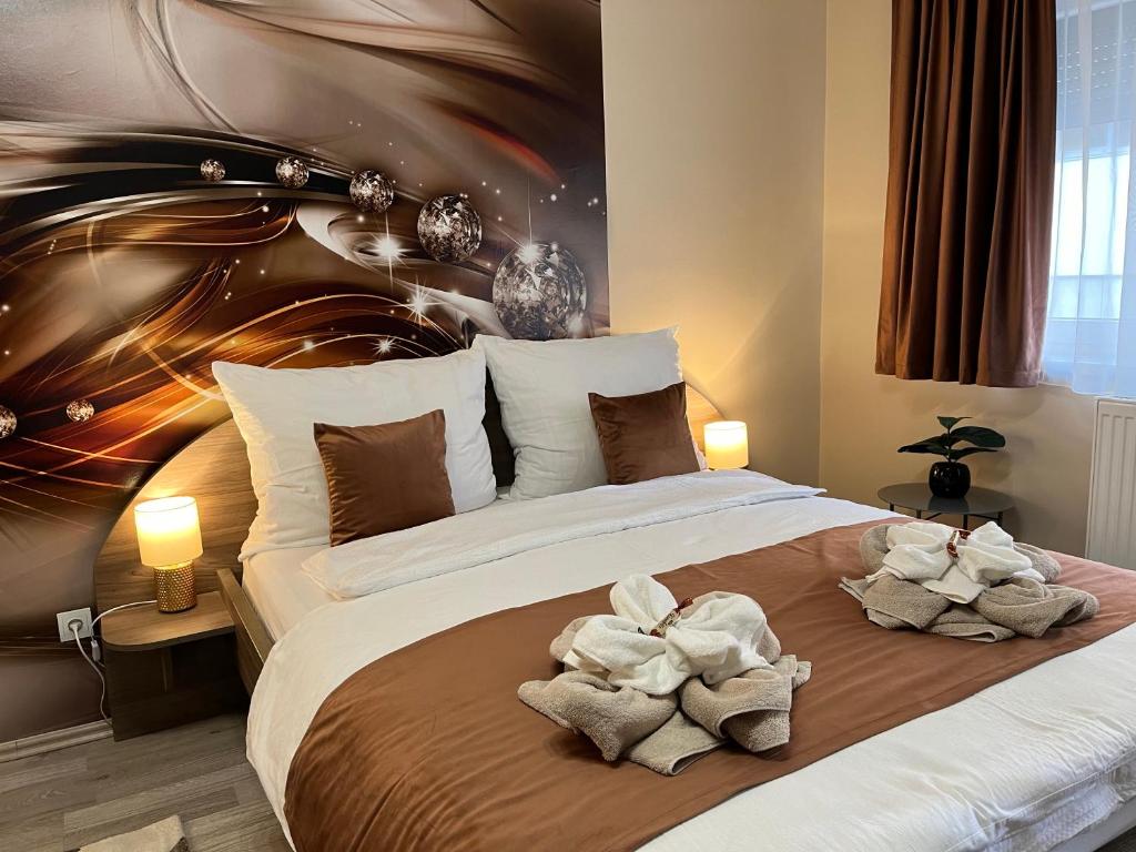 una camera da letto con un grande letto con asciugamani di Oreo Apartman a Eger
