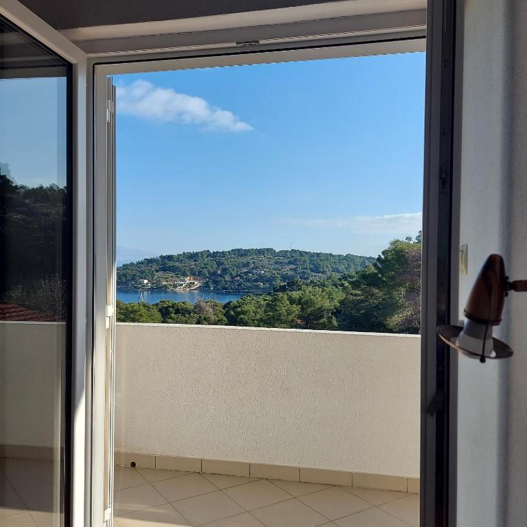 a sliding glass door with a view of the water at Villa Šolta in Rogač
