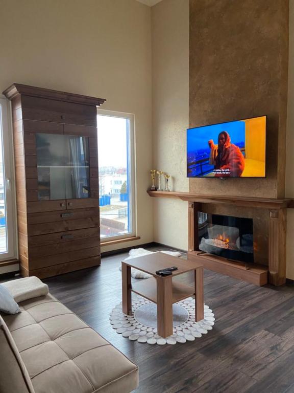 sala de estar con chimenea y TV en Penzión IMRICH CAR, en Prešov