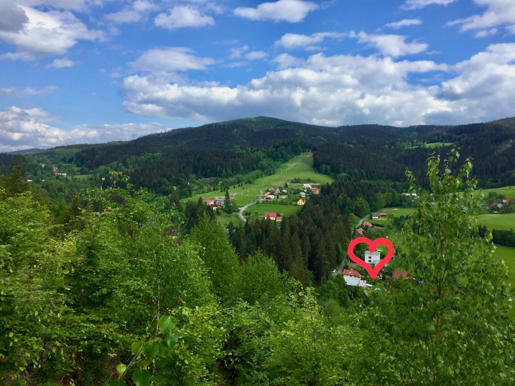 czerwone serce na szczycie wzgórza z drzewami w obiekcie Apartmány U Studánky w mieście Horní Bečva