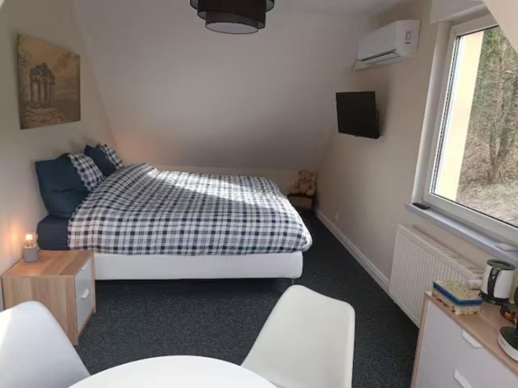 ein kleines Schlafzimmer mit einem Bett und einem Fenster in der Unterkunft La Fontaine Aux Enfants - Chambre avec sdb privée in Abreschviller