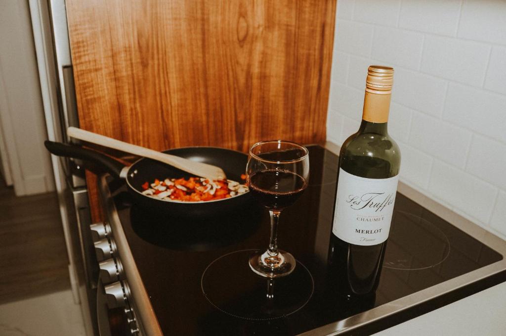 a bottle of wine and a glass on a stove at Suite 109 - Destination Mont-Orford in Magog-Orford