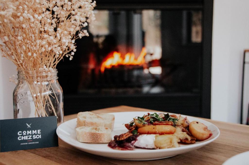 a plate of food on a table with a fireplace at Suite 110 - Destination Mont-Orford in Magog-Orford