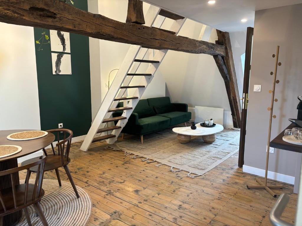 - un salon avec un canapé vert et une échelle dans l'établissement La maison d'Aline, à Arras