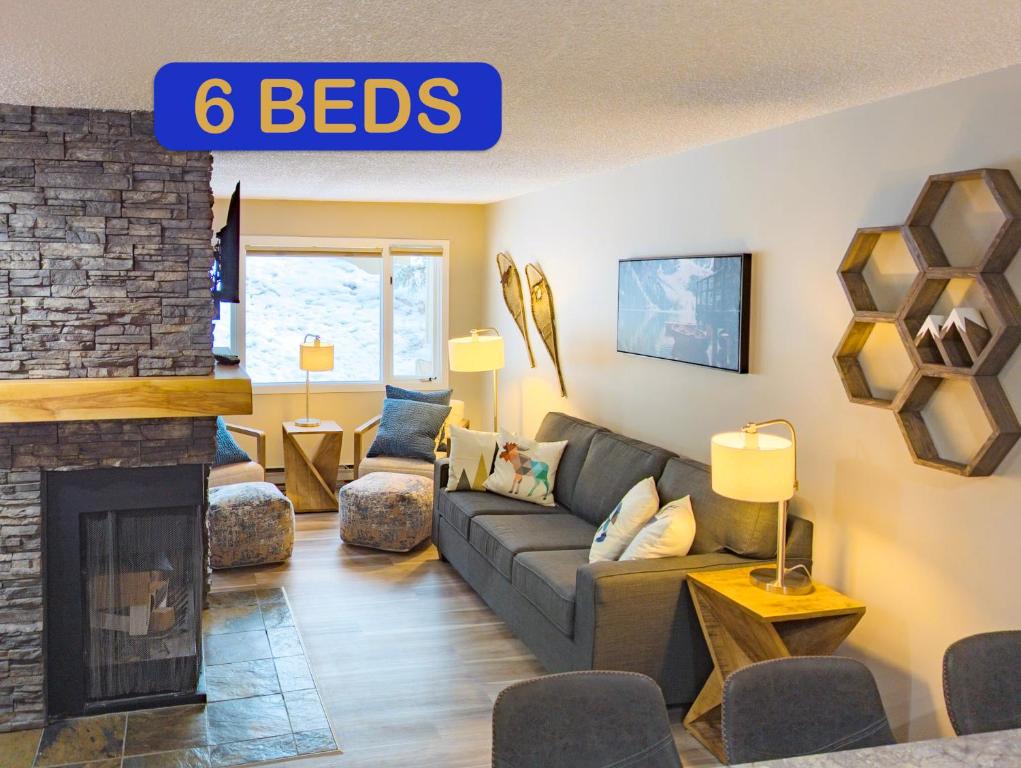 a living room with a couch and a fireplace at 2 Bedroom and Wall Bed Mountain Getaway Ski In Ski Out Condo with Hot Pools Sleeps 8 in Panorama