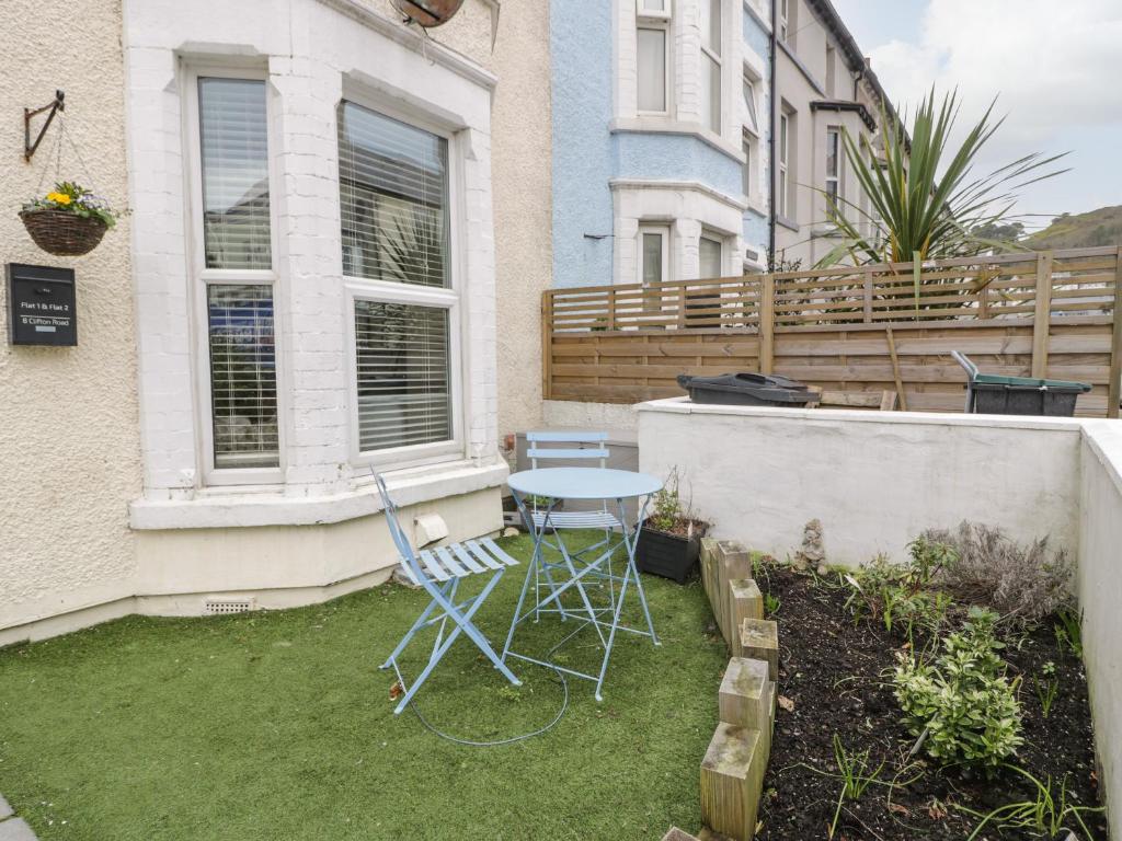 a patio with a table and chairs in a yard at Apartment 2 - Llandudno Central in Llandudno