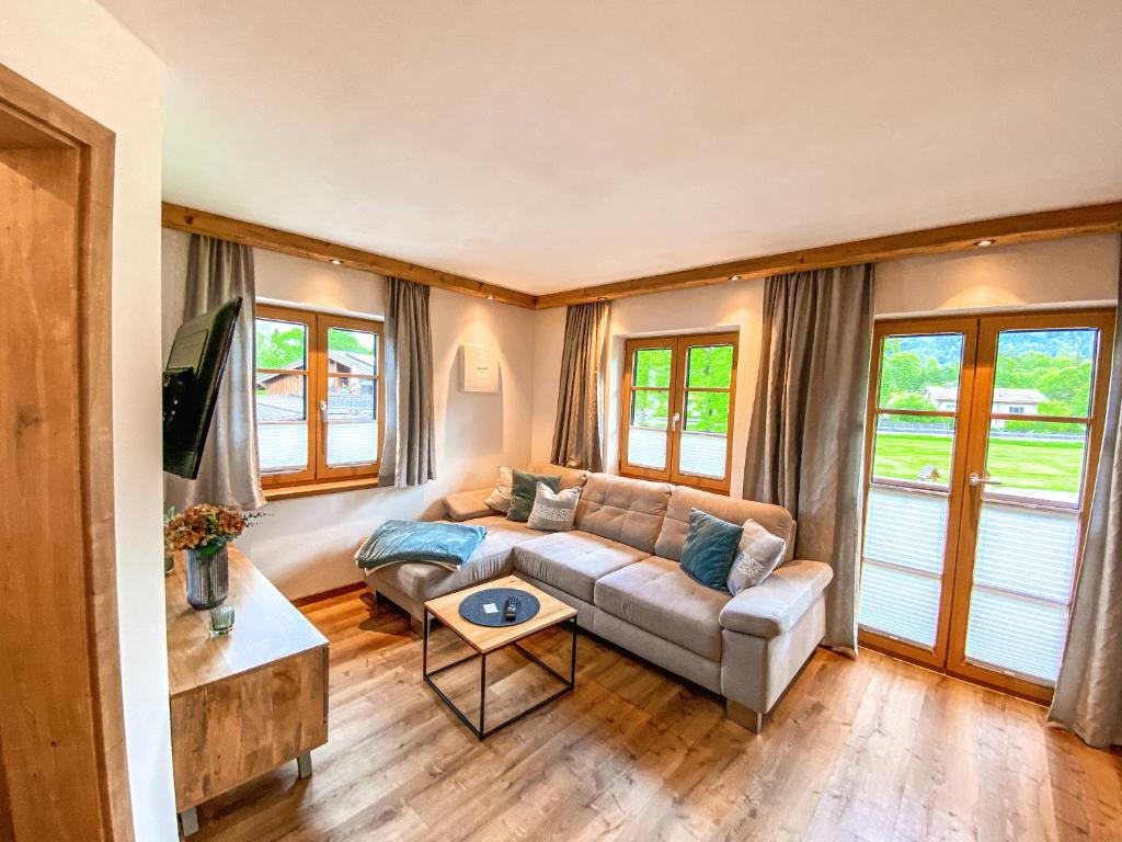ein Wohnzimmer mit einem Sofa und einem Tisch in der Unterkunft Ferienwohnungen Gastager Hof in Ruhpolding