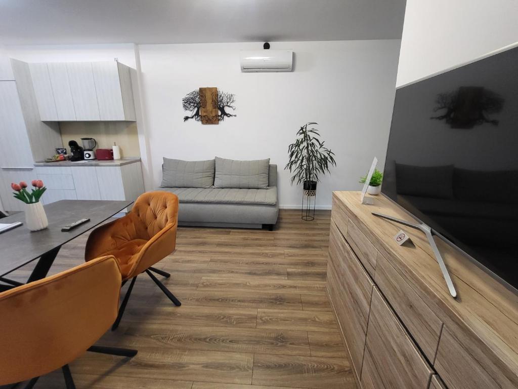ein Wohnzimmer mit einem Tisch und einem Sofa in der Unterkunft Sika Sunny Garden Apartment in Arad