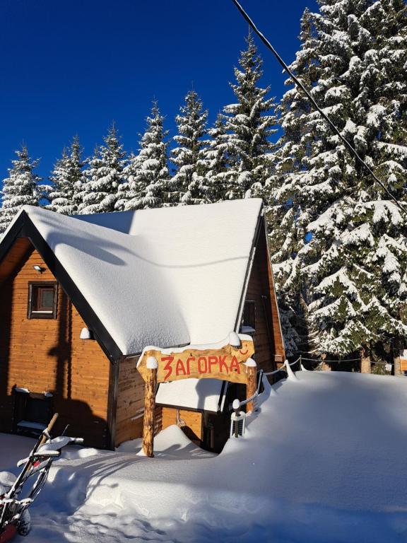 a cabin in the snow with a sign on it at Villa Zagorka and mountain houses A, M, D in Kopaonik