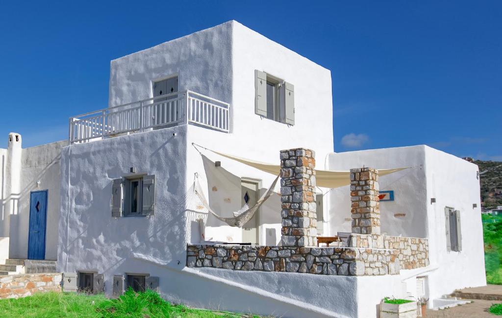uma casa branca com uma porta azul em Empiria House - Agia Irini - Paros em Agia Irini Paros