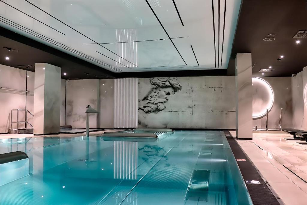 a swimming pool in a building with a painting on the wall at Flatbook - City Center SPA Apartments Deo Plaza in Gdańsk