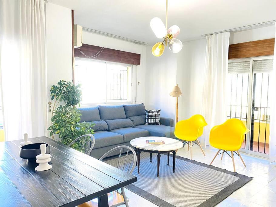 een woonkamer met een blauwe bank en gele stoelen bij San Gil in Cenes de la Vega