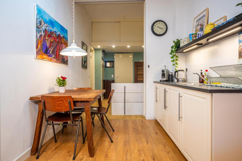 eine Küche und ein Esszimmer mit einem Holztisch und Stühlen in der Unterkunft Fully fitted room - 15 min from central station in Amsterdam
