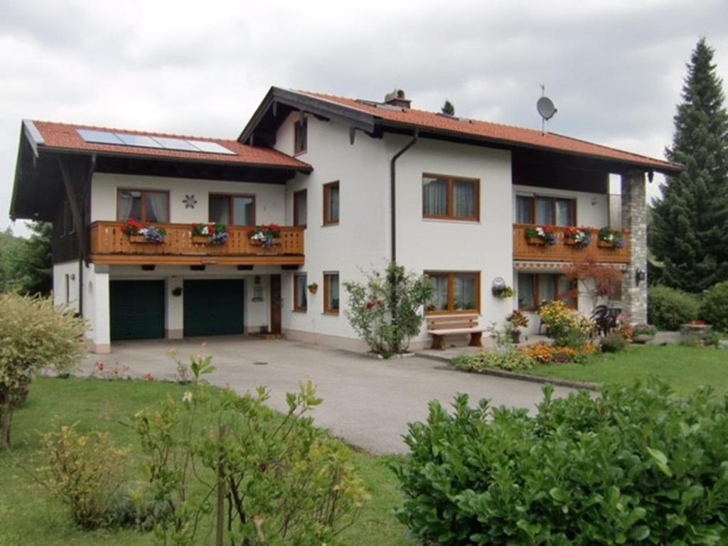 a large white house with a balcony at Ferienwohnung Deininger inkl. Chiemgaukarte in Ruhpolding